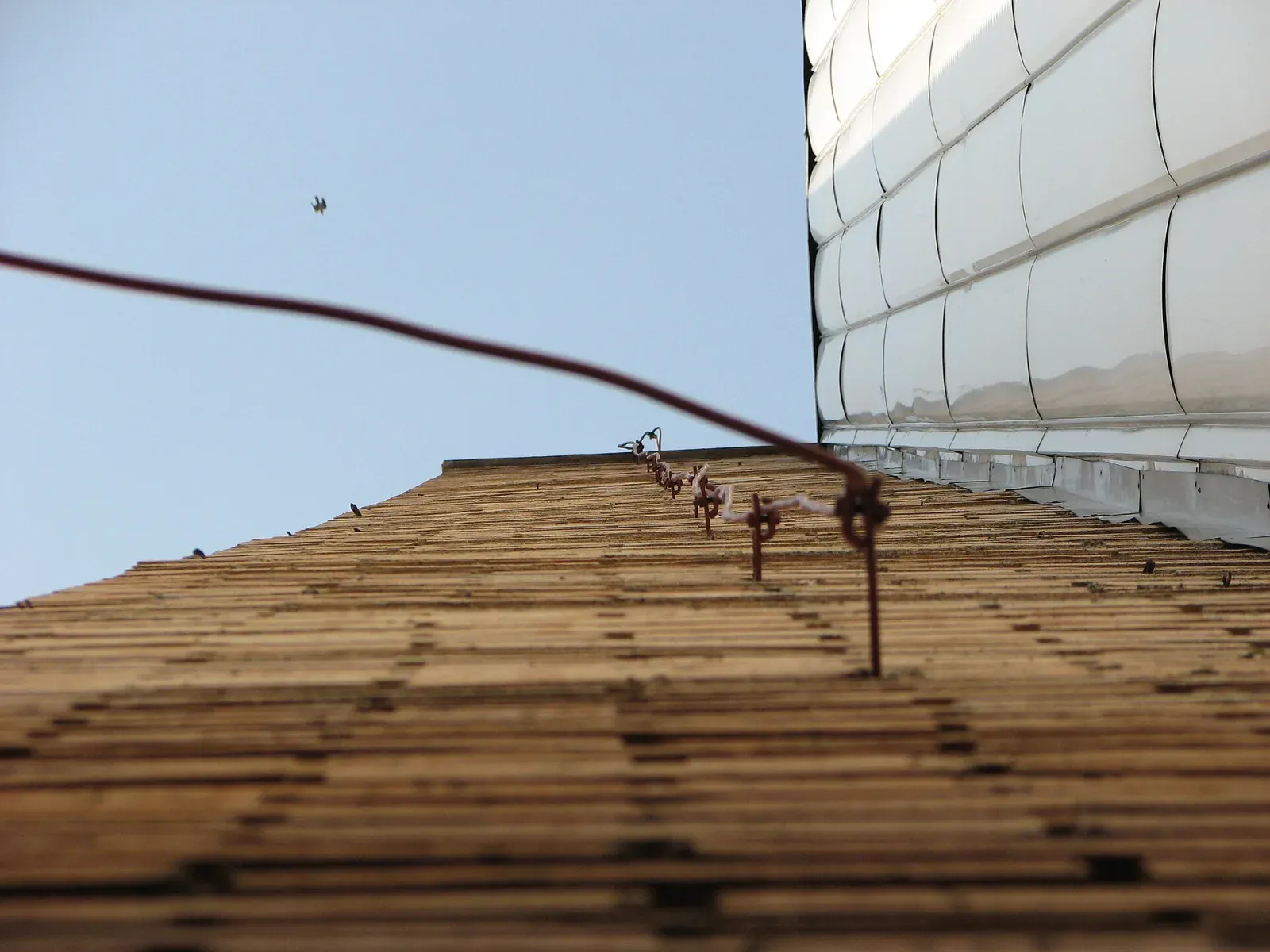 Air terminal on a brick chimney with a conductor running along the roof