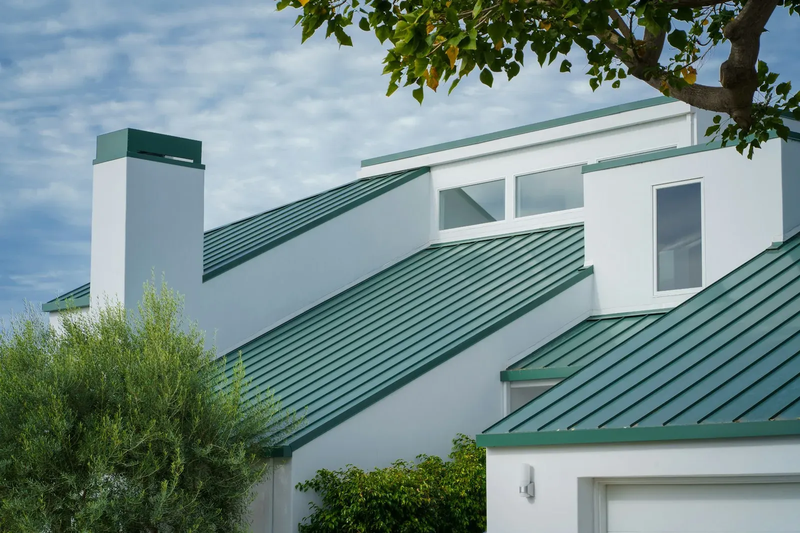 White house with a green standing-seam metal roof