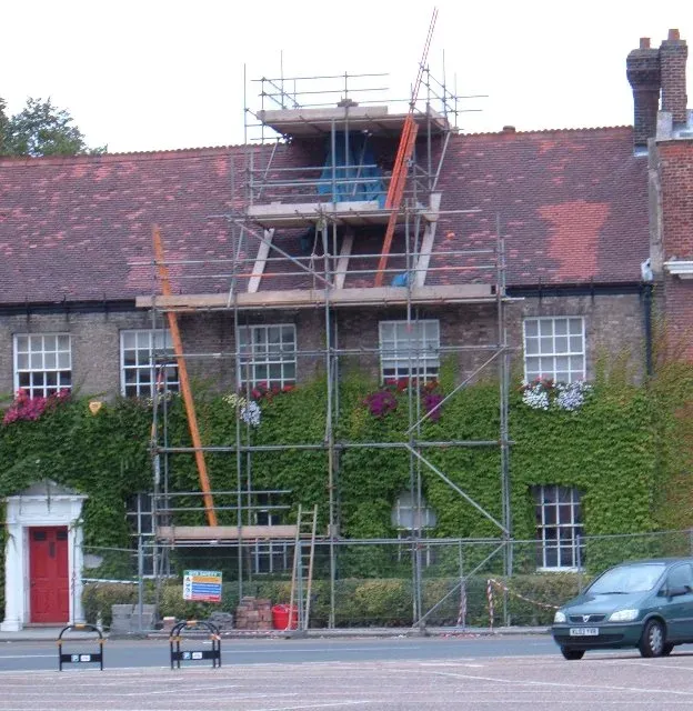 Scaffolding around the chimney of a brick building being repaired after it was struck by lightning