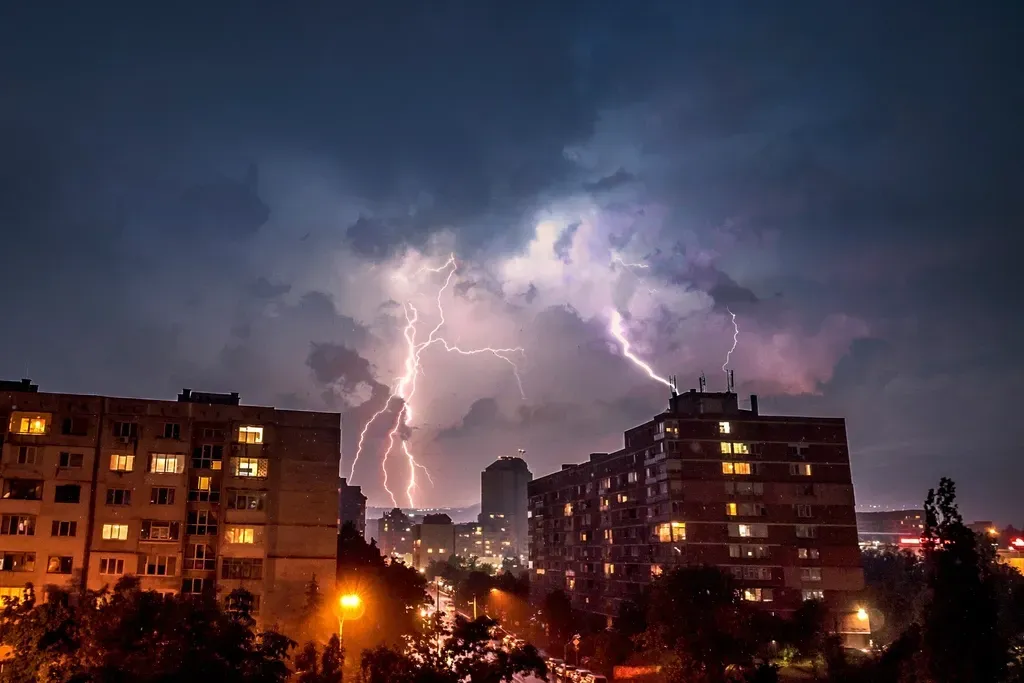 Lightning strikes over apartment buildings at night