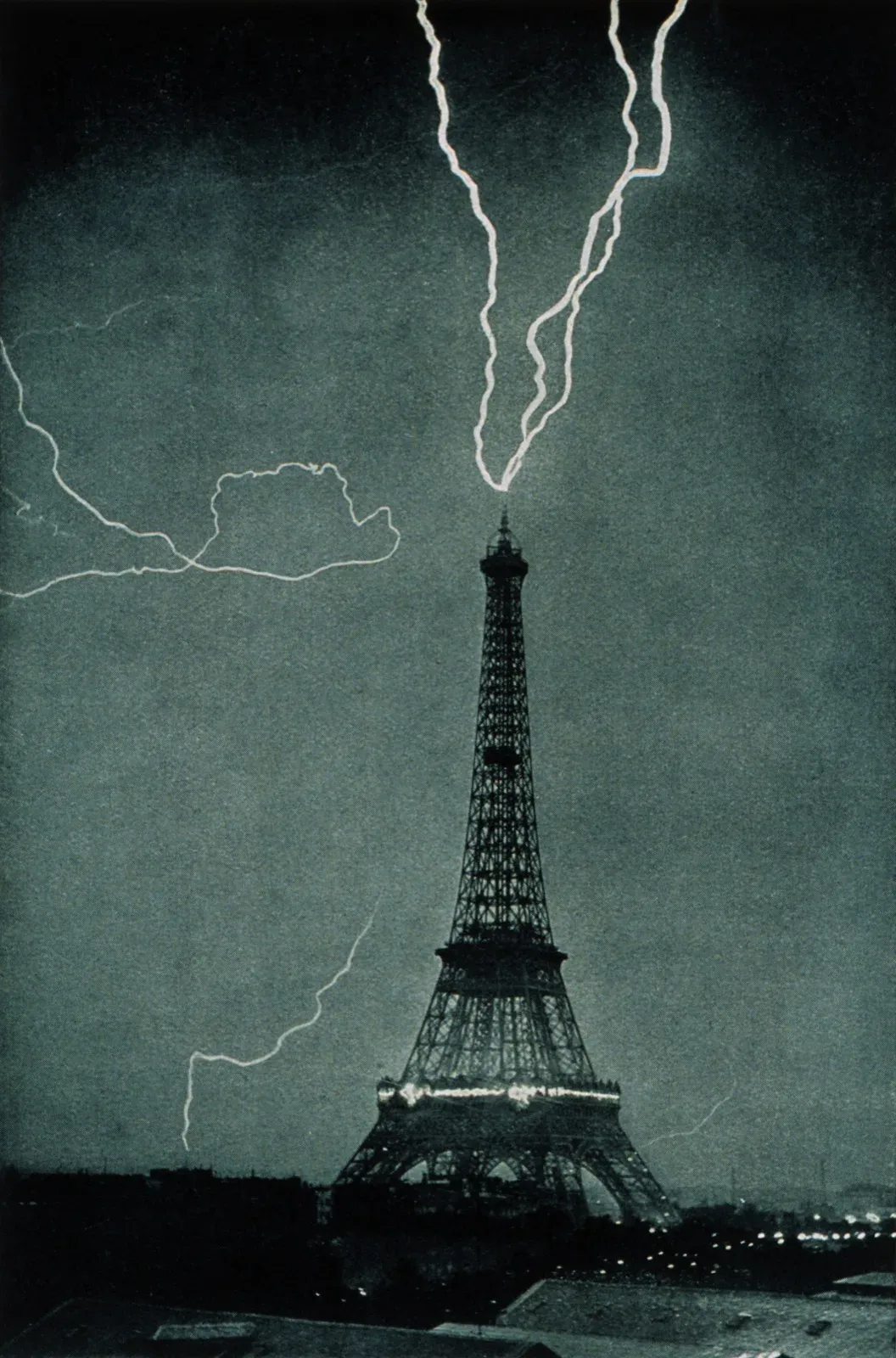 Black and white photo of a lightning bolt striking the top of the Eiffel Tower at night in 1902