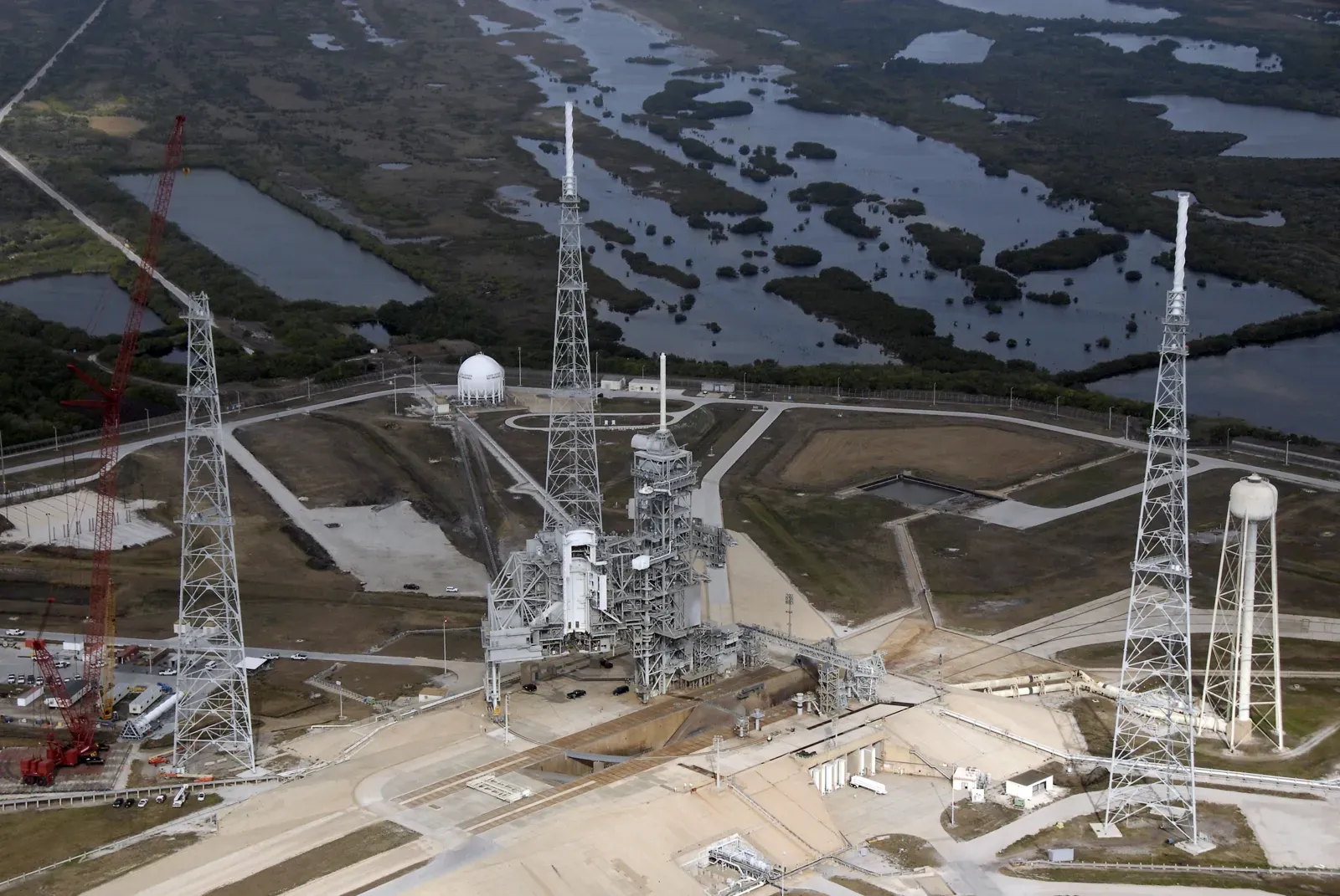 Aerial view of three lightning protection towers with masts around Launch Pad 39B at Kennedy Space Center
