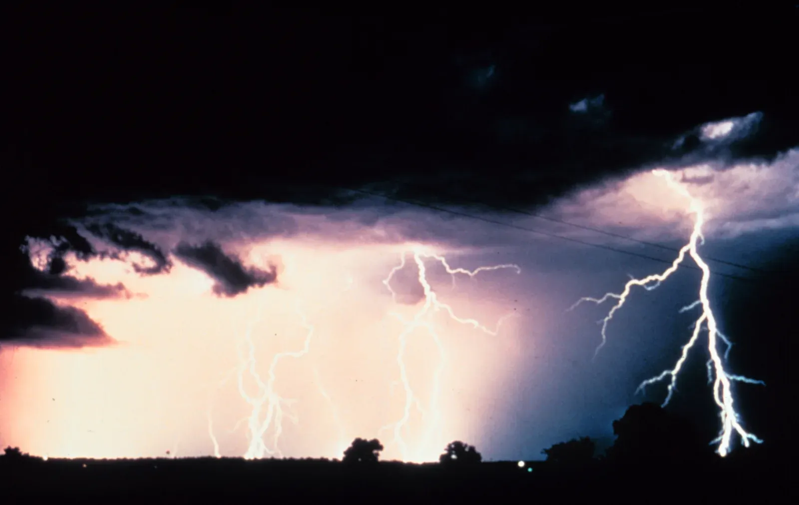 Time-lapse photo of multiple cloud-to-ground and cloud-to-cloud lightning strokes at night