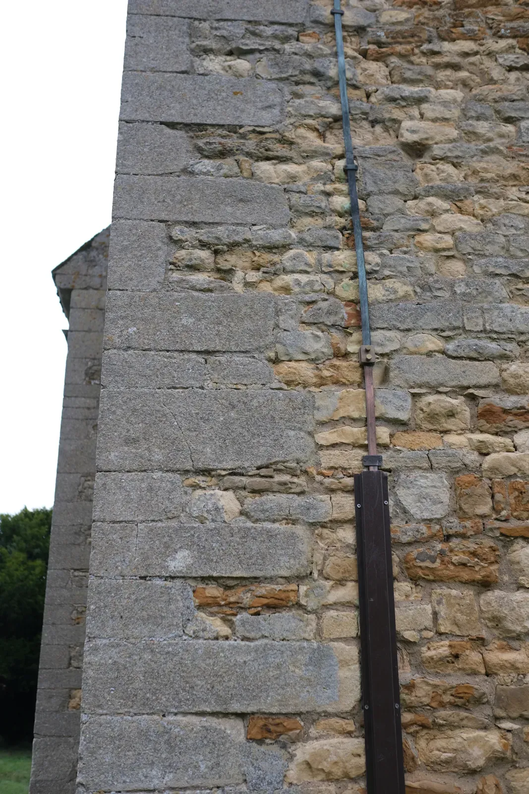 Newly fitted lightning conductor running down a stone wall