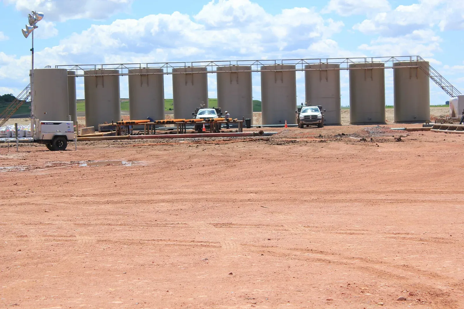 Row of steel tanks in an oil field tank battery on a gravel pad near Williston, North Dakota