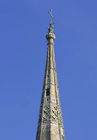 Top of the stone spire of Salisbury Cathedral, a tall church steeple exposed to lightning